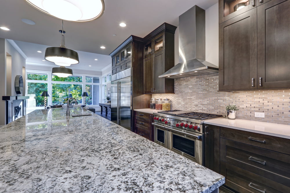 Modern kitchen with granite countertop and stainless steel appliances.