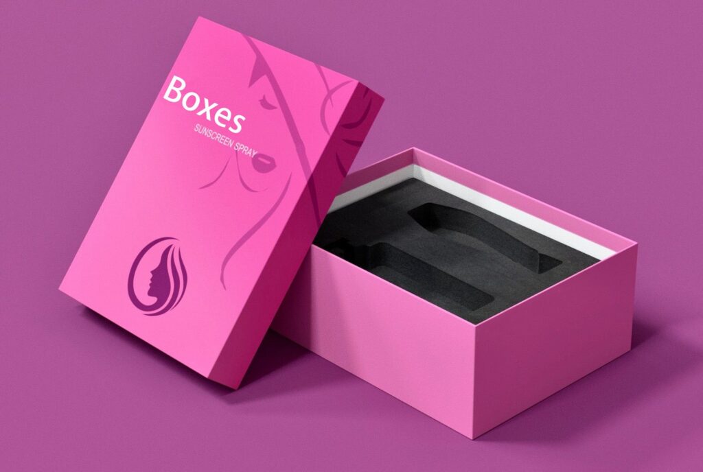 A stylish pink packaging box for sunscreen spray with a minimalist design, featuring a custom foam insert for product protection.