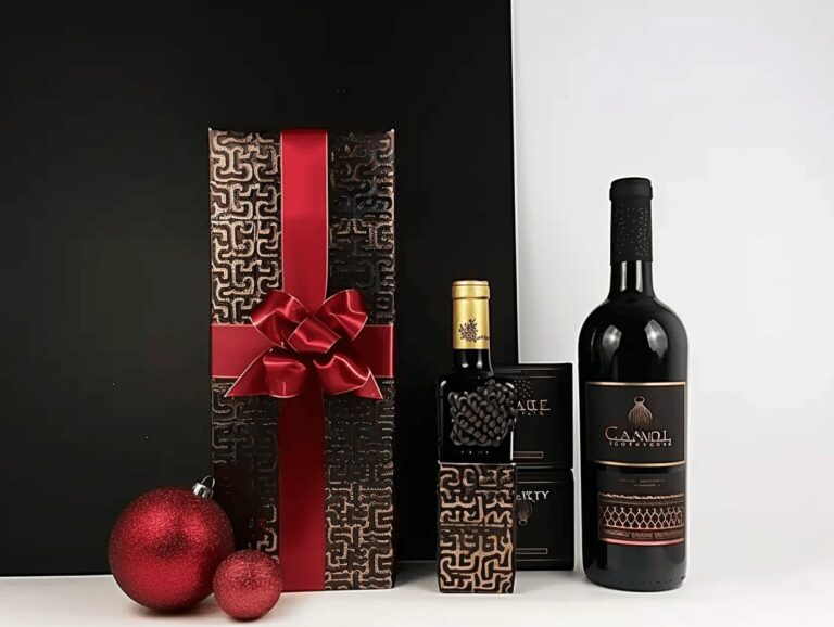 Elegant wine gift set featuring a large bottle, a smaller bottle, and luxurious packaging with embossed patterns and a vibrant red ribbon, accompanied by decorative red ornaments.