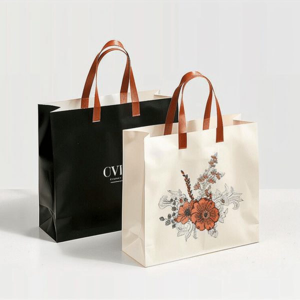 Stylish paper bags in black and cream colors with floral patterns and sturdy handles.